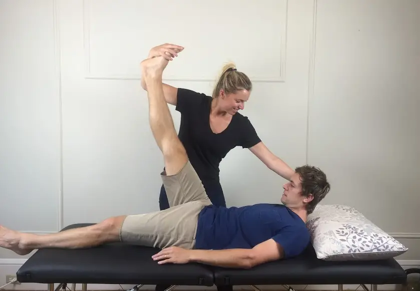 therapist performing a clinical test to clarify the diagnosis of back pain