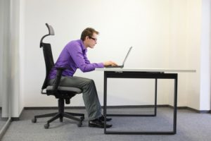 homme ayant une posture affaissée devant son ordinateur