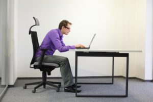 mand med en nedslidt stilling foran sin computer