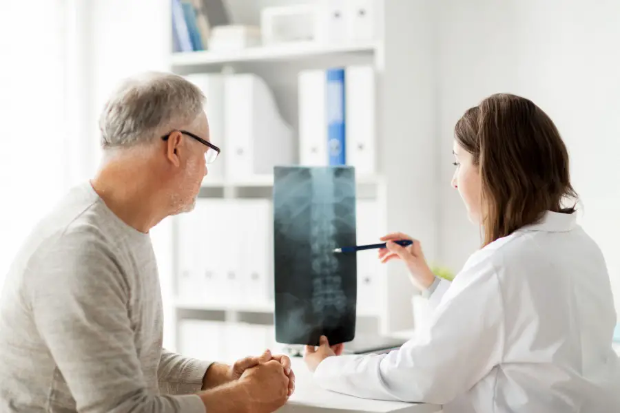 médico examinando imagens médicas das costas de seu paciente