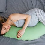 Beautiful pregnant woman sleeping with body pillow